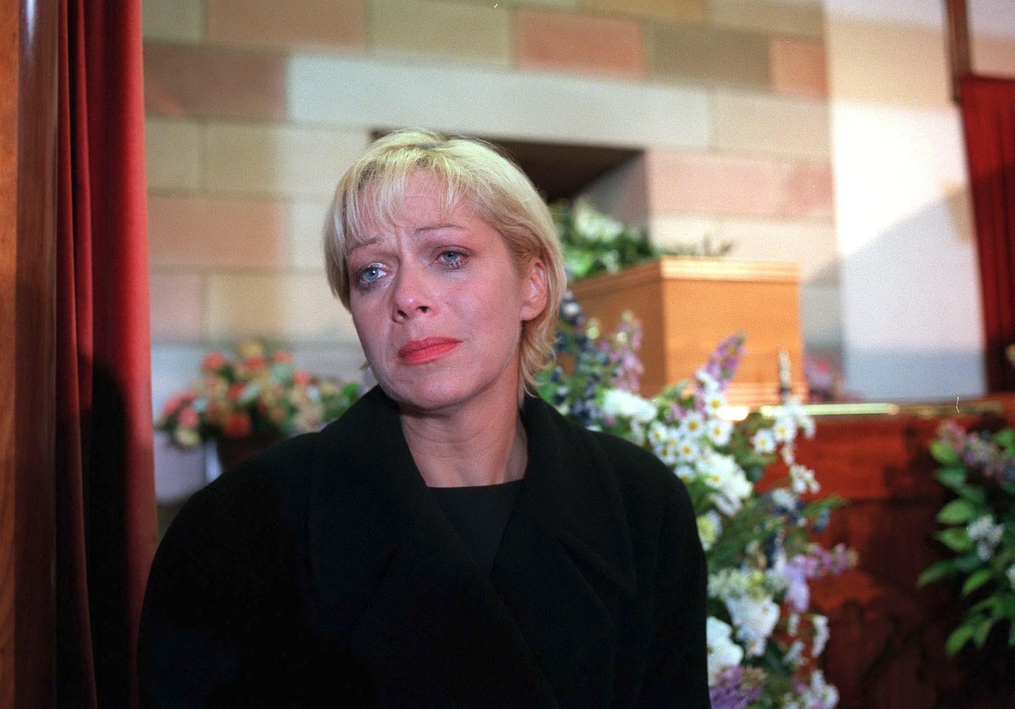 Natalie Barnes cries in front of her husband's coffin