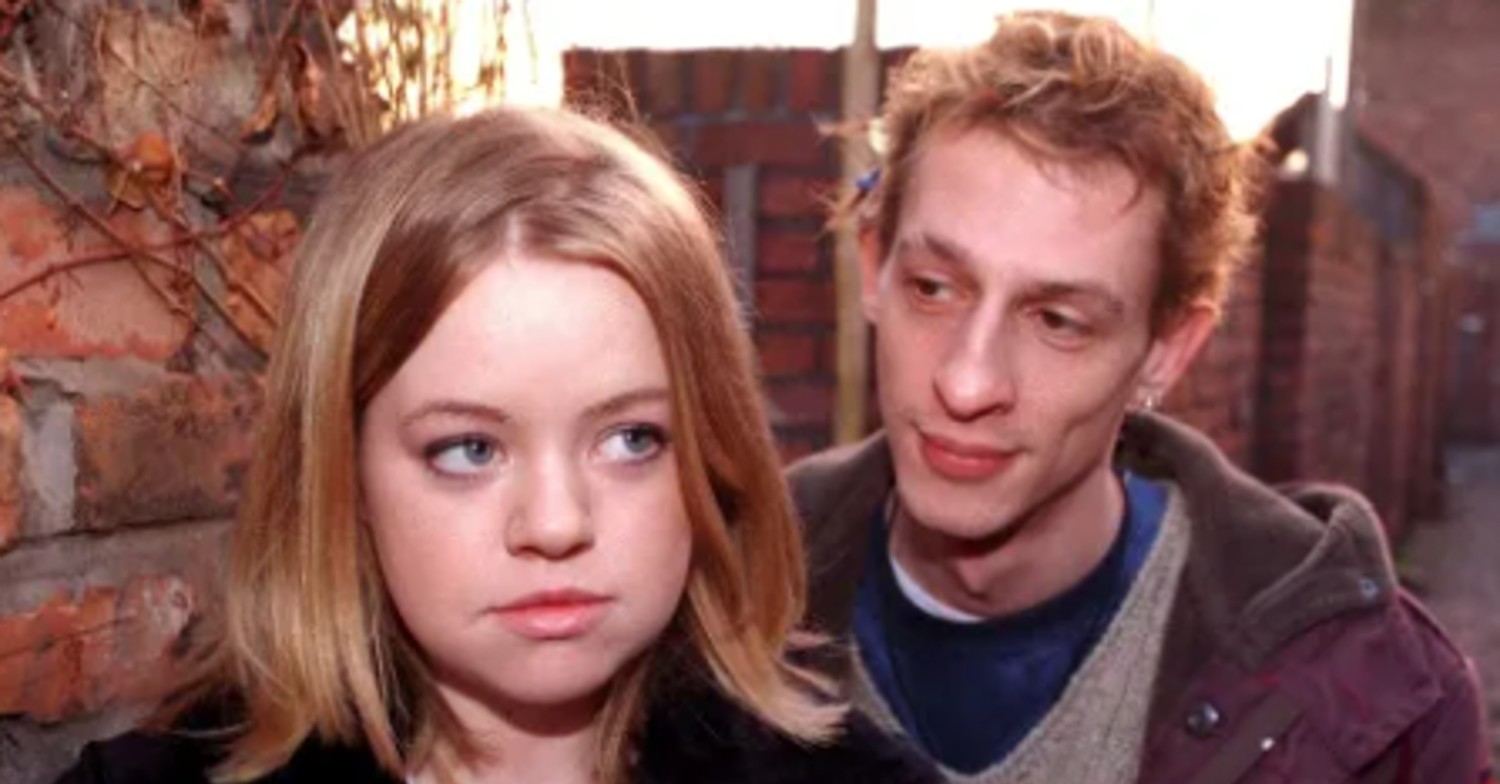 Coronation Street's Toyah looks worried as Spider watches over her shoulder (Credit: ITV)