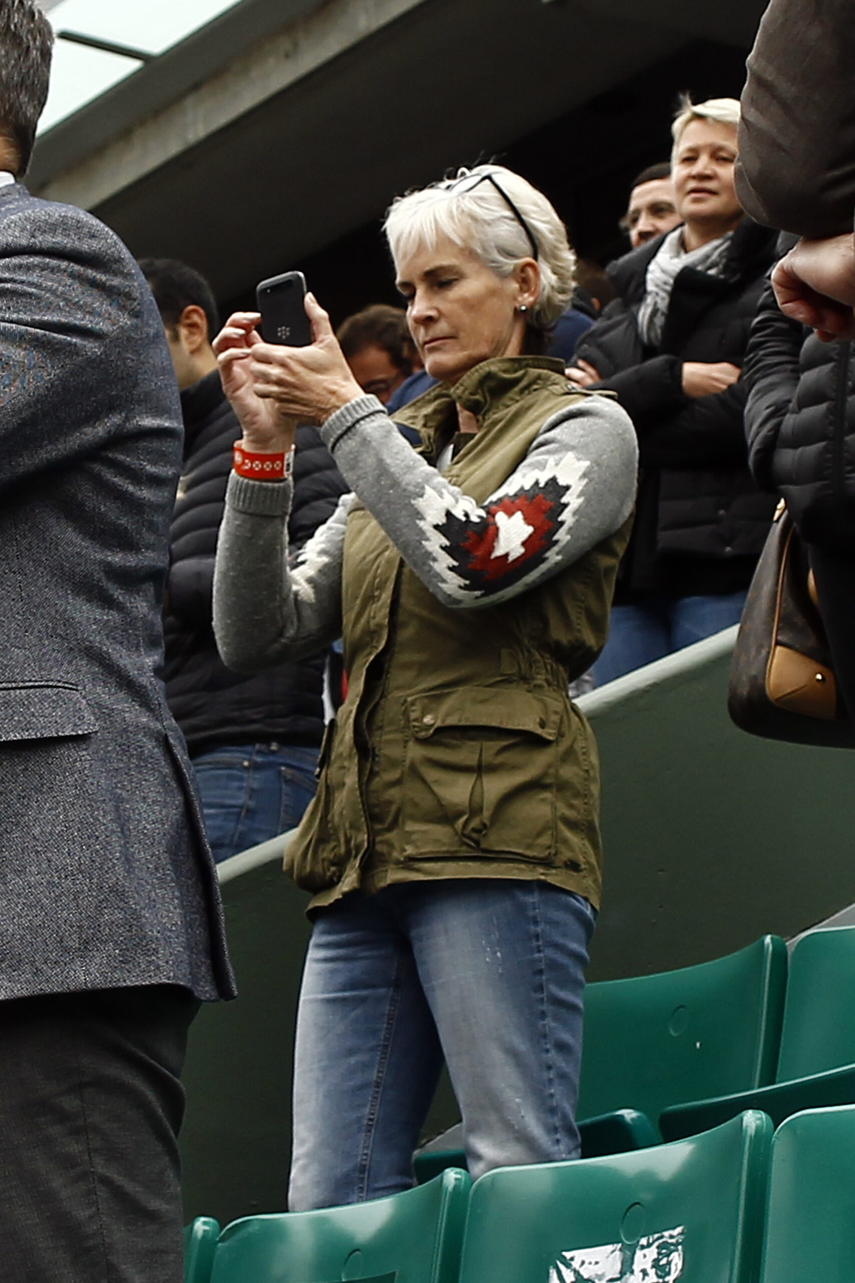Judy Murray checking her phone as she watches the tennis. (Credit: SplashNews)