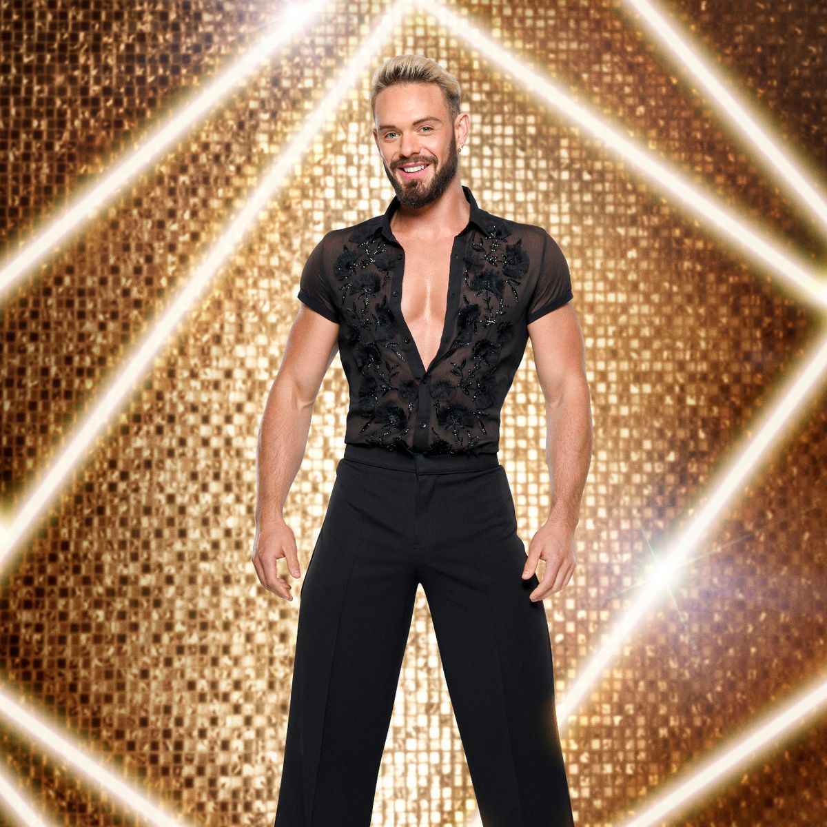John poses in a tight black outfit on the Sparkling set on Strictly 