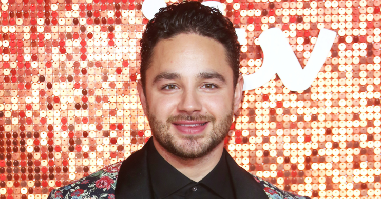Adam Thomas standing against a glittery background