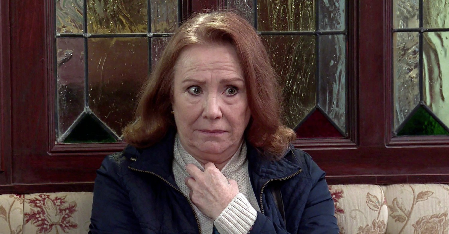 Cathy Matthews looks worried and clutches hand to chest while sitting in the Rovers (Credit: ITV)