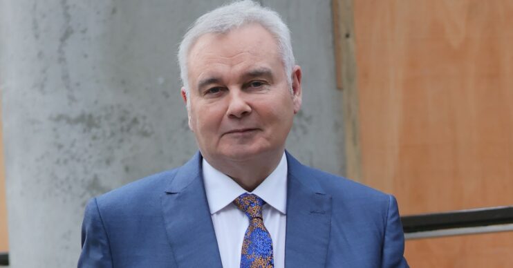 Eamonn Holmes smirking in blue suit outside TV studios