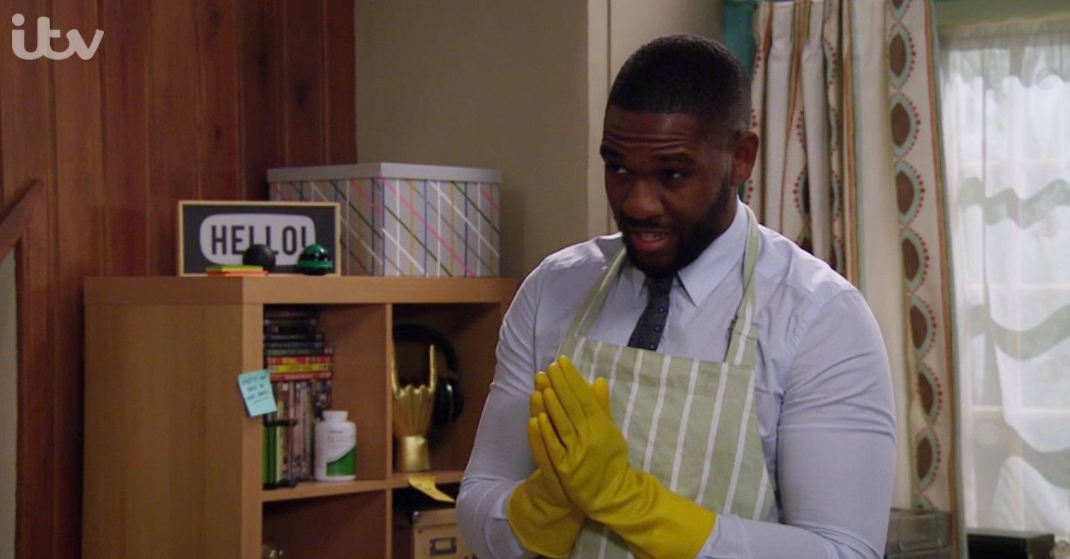 Ethan Anderson wearing yellow rubber gloves in Emmerdale