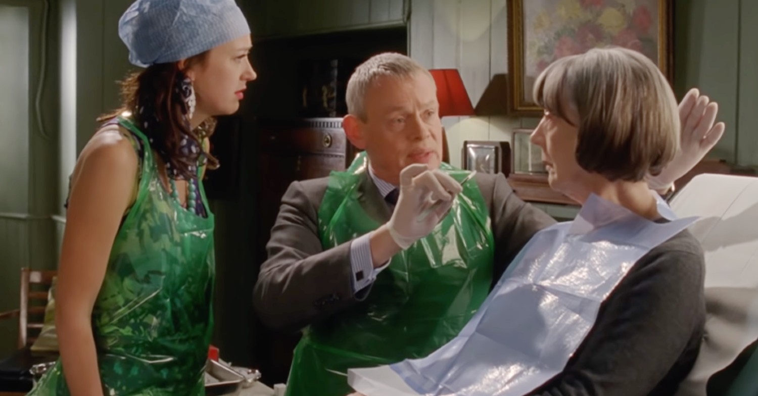 Doc Martin season 10 star Martin Clunes in character working on a patient 