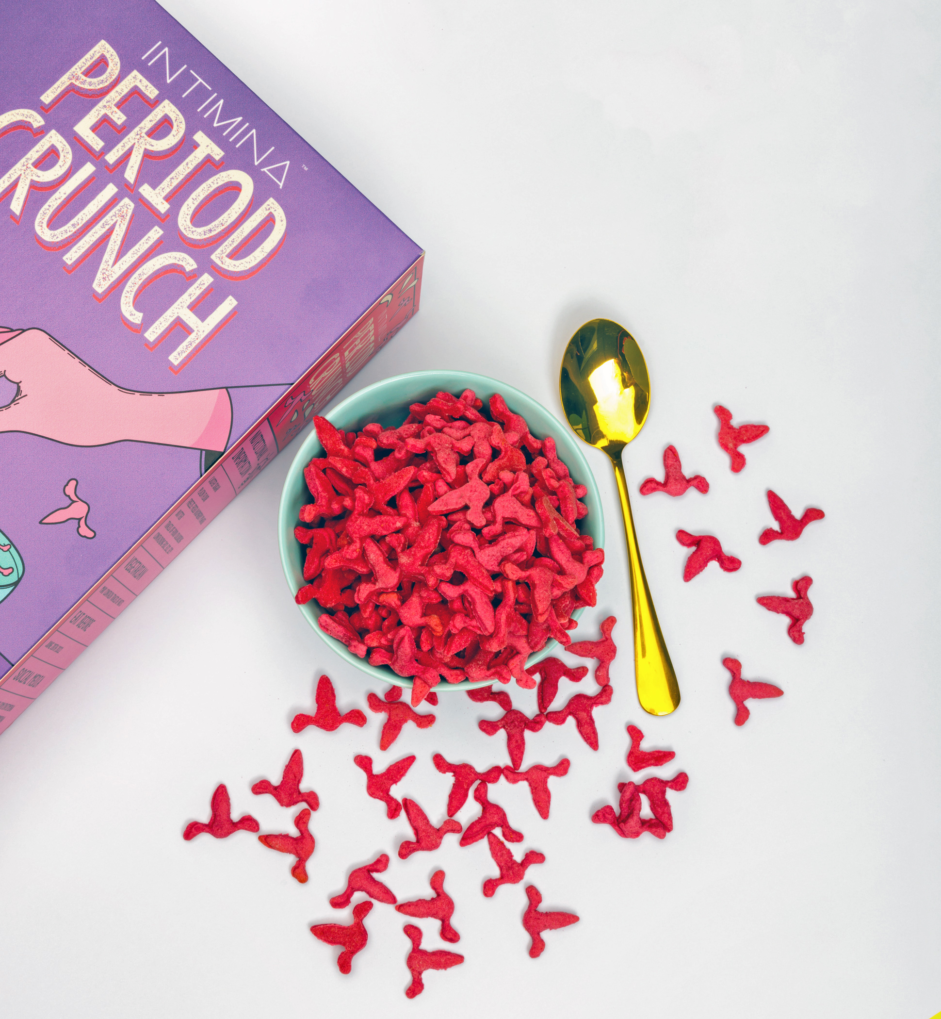 Menstrual-themed breakfast cereal Period Crunch in a bowl of milk alongside box and spoon