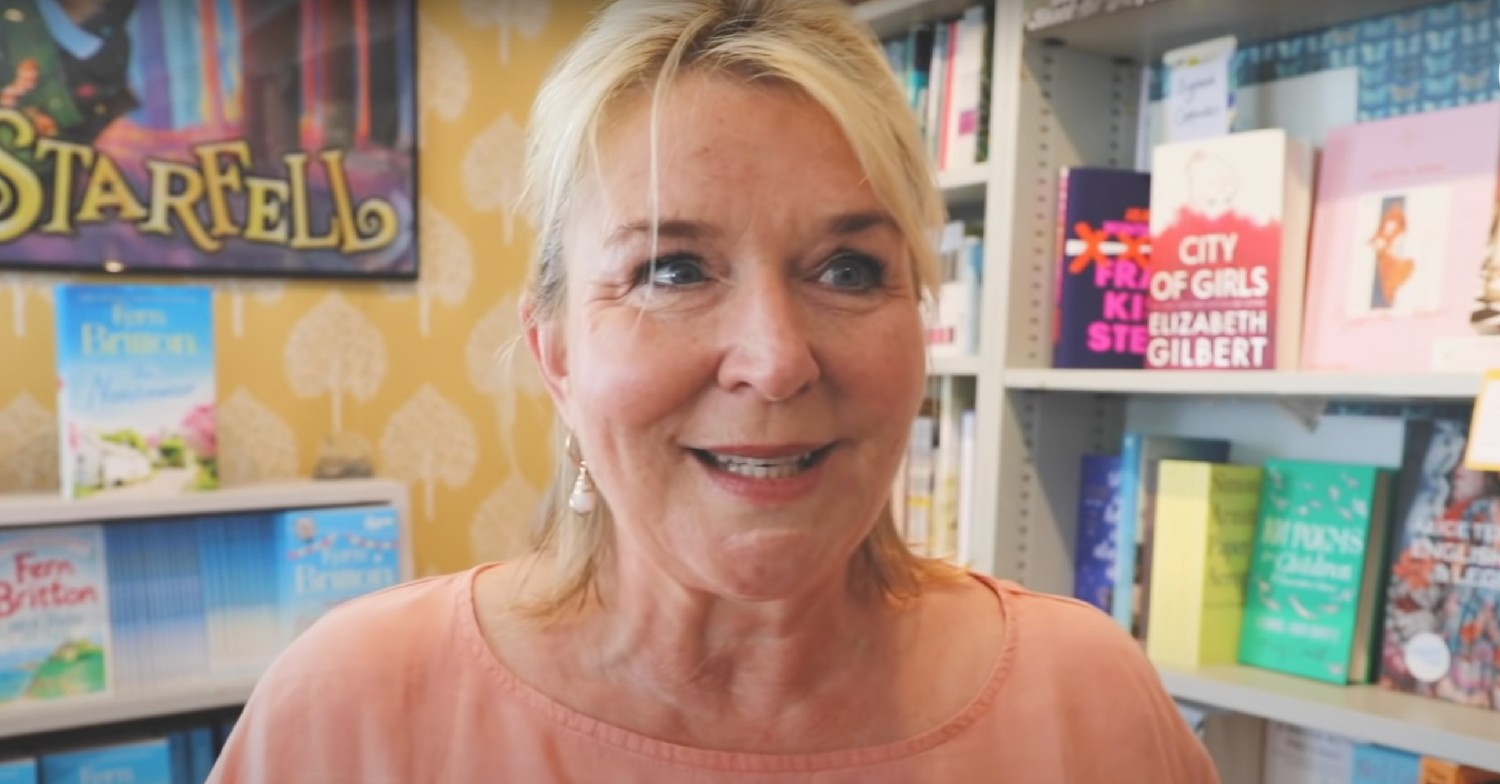 Fern Britton smiling and talking to camera, whilst in a bookshop