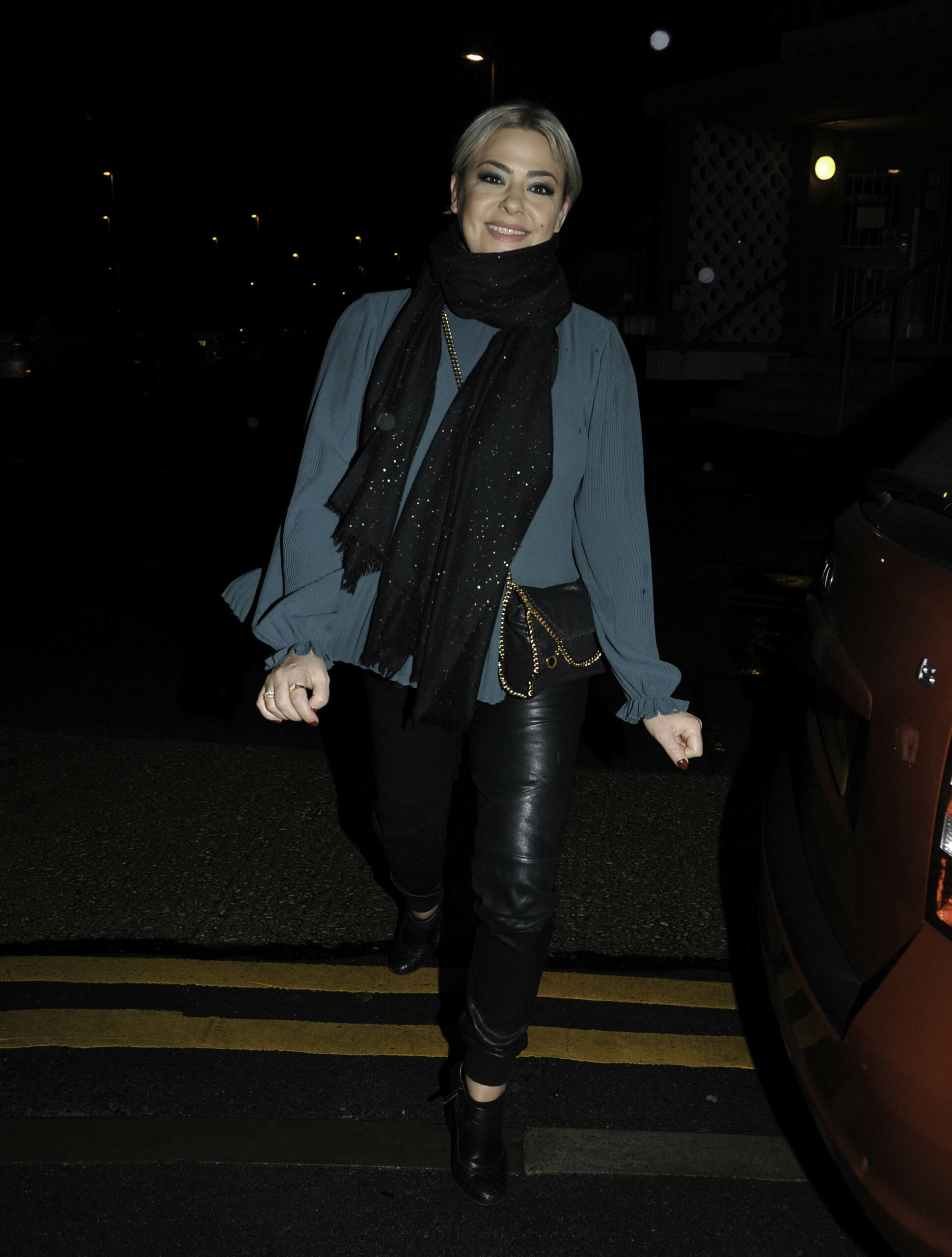 Lisa Armstrong smiling while wearing a green top and scarf