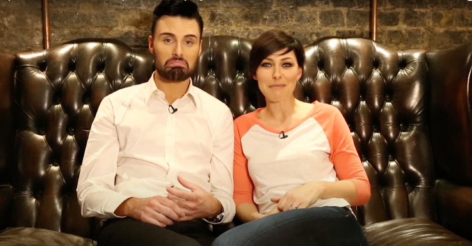 Big Brother hosts Rylan Clark and Emma Willis sitting on a sofa talking to the camera 
