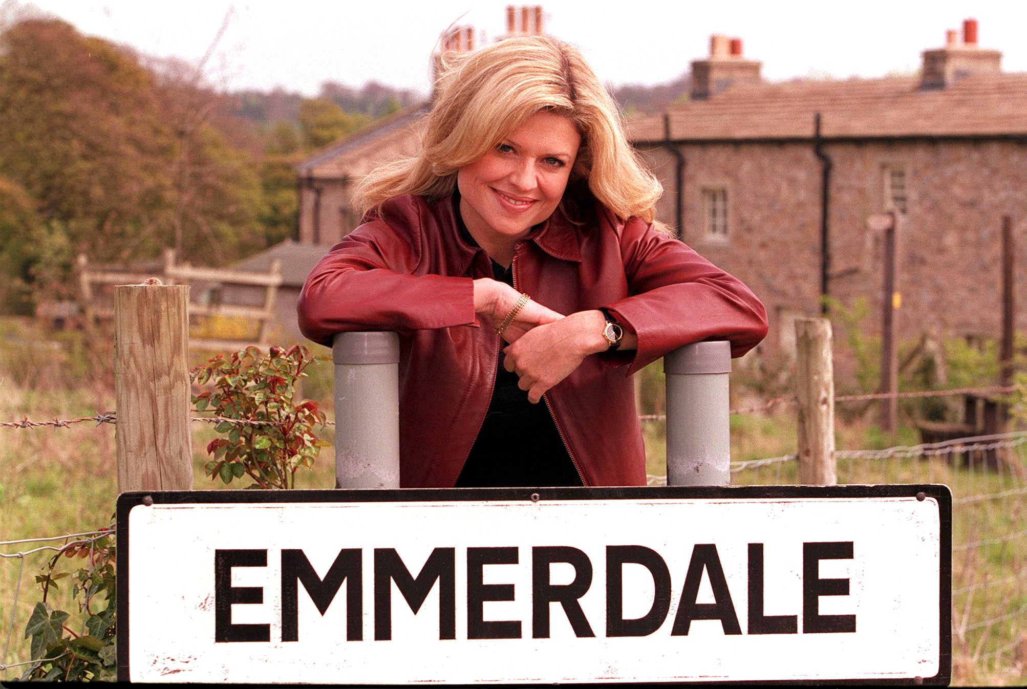 Louise Appleton smiles as she poses with the Emmerdale sign