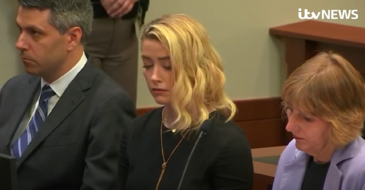 Amber Heard looks down alongside her lawyers during court trial verdict