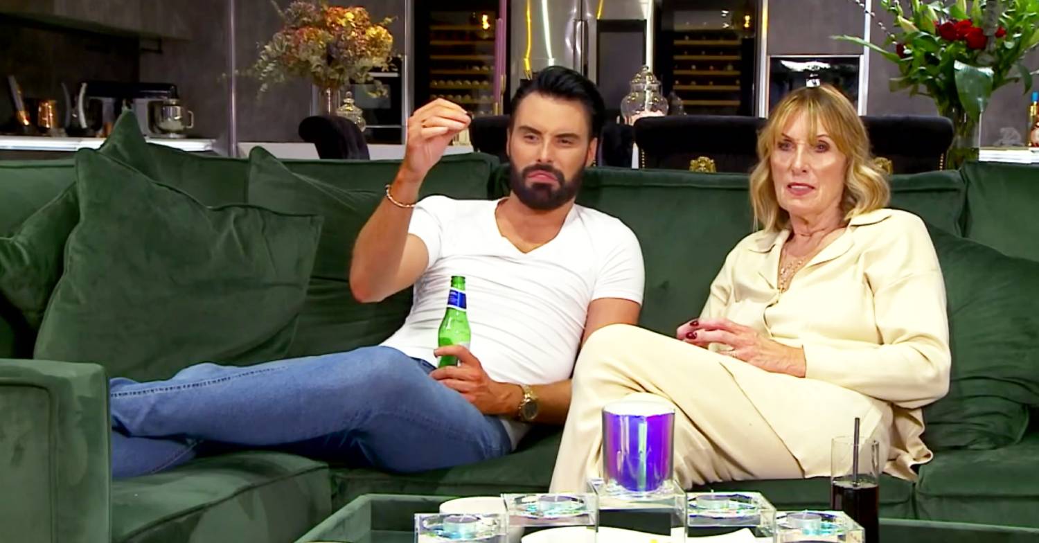 Celebrity Gogglebox star Rylan holds a bottle and his mum Linda sits next to him