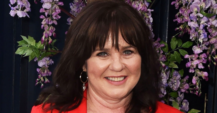Coleen Nolan smiling wearing red