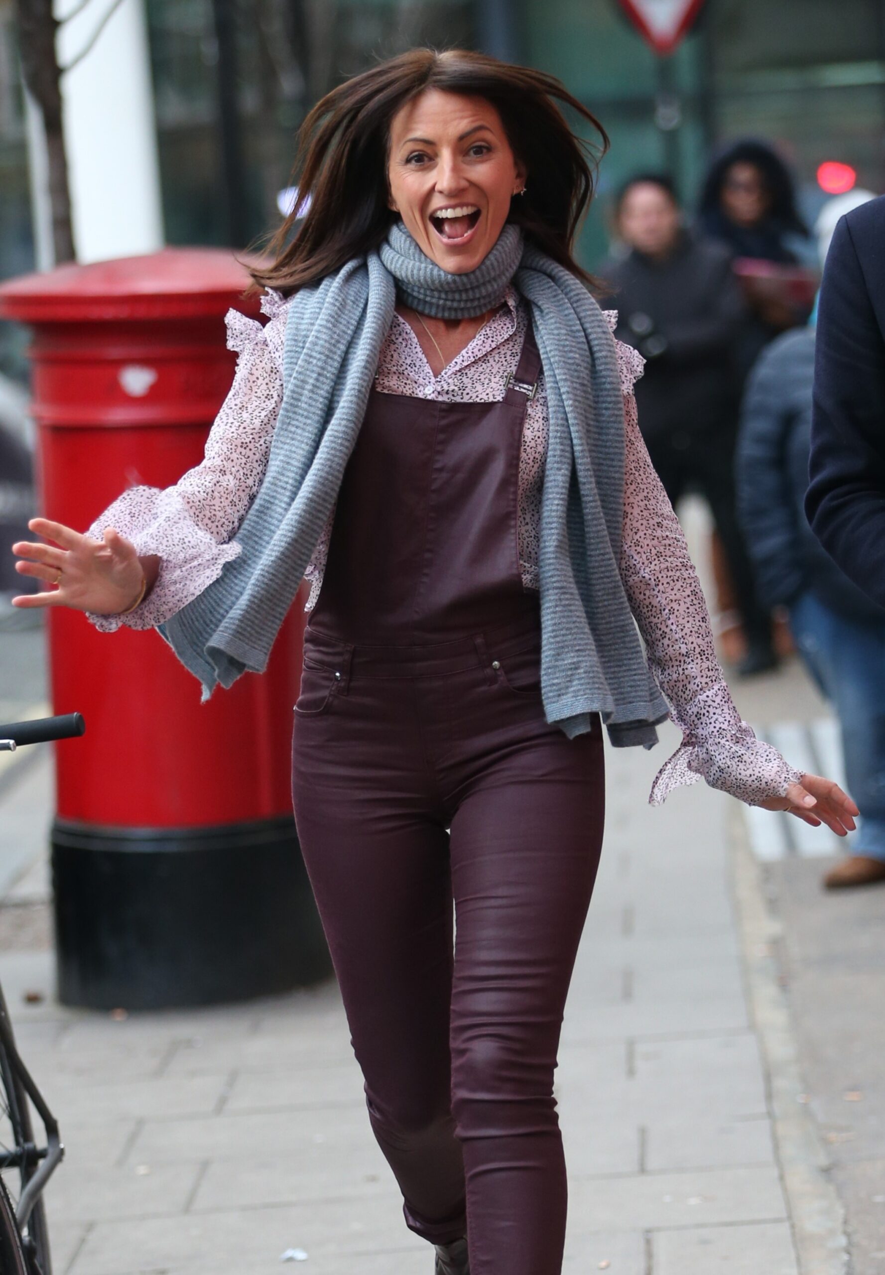Davina McCall grinning as she struts down the street