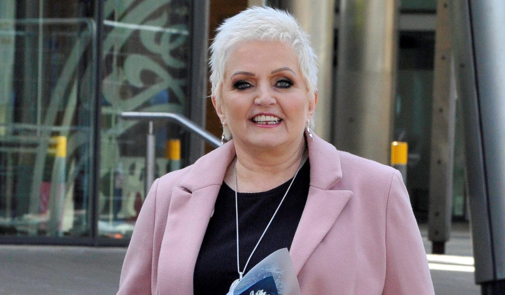 Linda Nolan smiling in a pink jacket