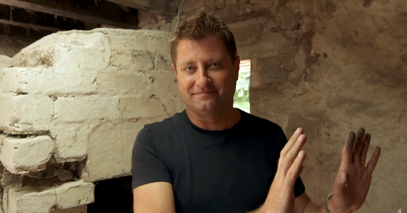 George Clarke in a dark basement smiling