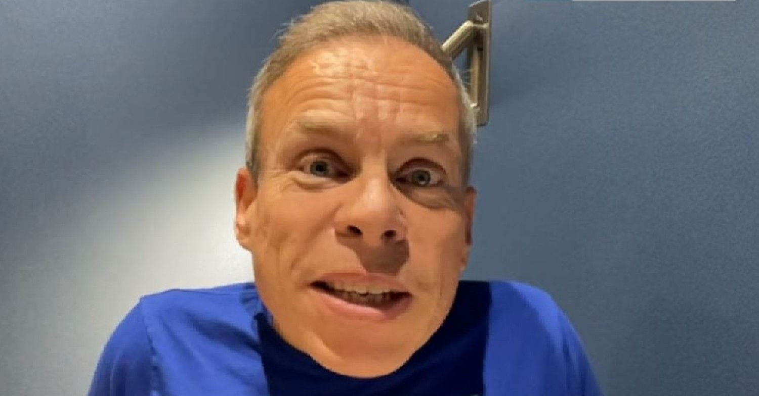 Tenable host Warwick Davis in blue t-shirt while speaking to camera on This Morning
