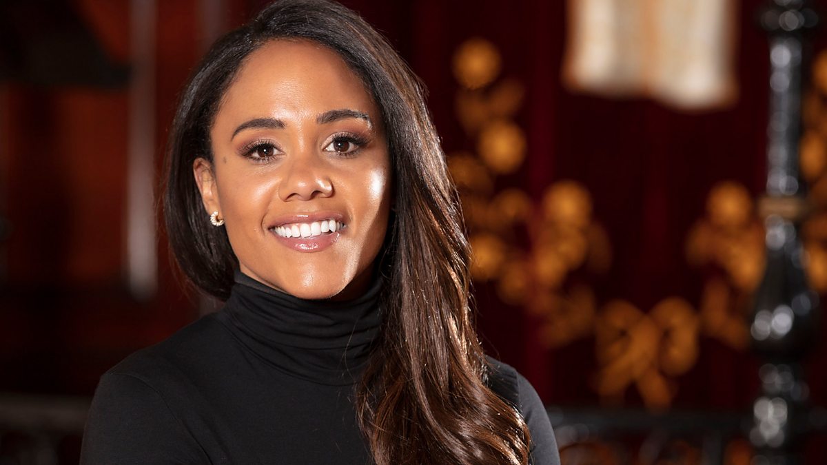 Alex Scott smiling wearing a black roll neck