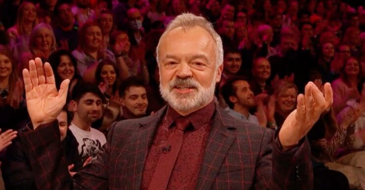 Graham Norton raises his hands in joy
