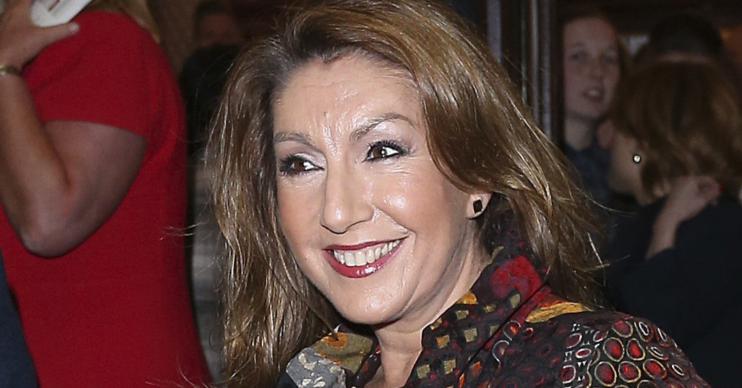 Jane McDonald smiling outside a theatre