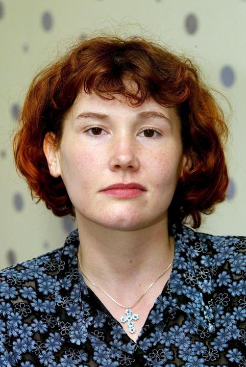 Image of MAXINE CARR, she smiles in a blue and black top