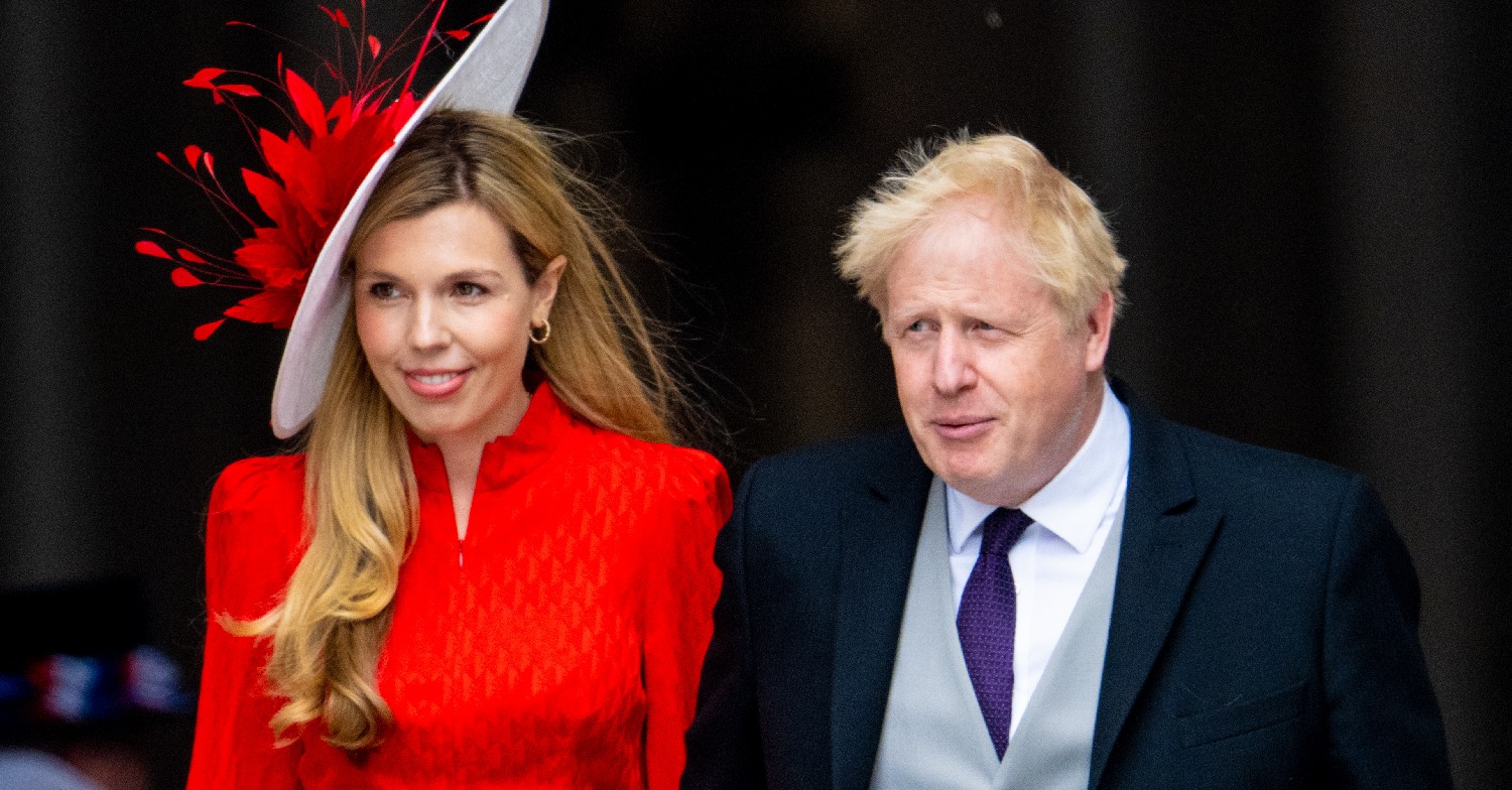 Carrie Johnson in a red dress and hat and Boris Johnson 