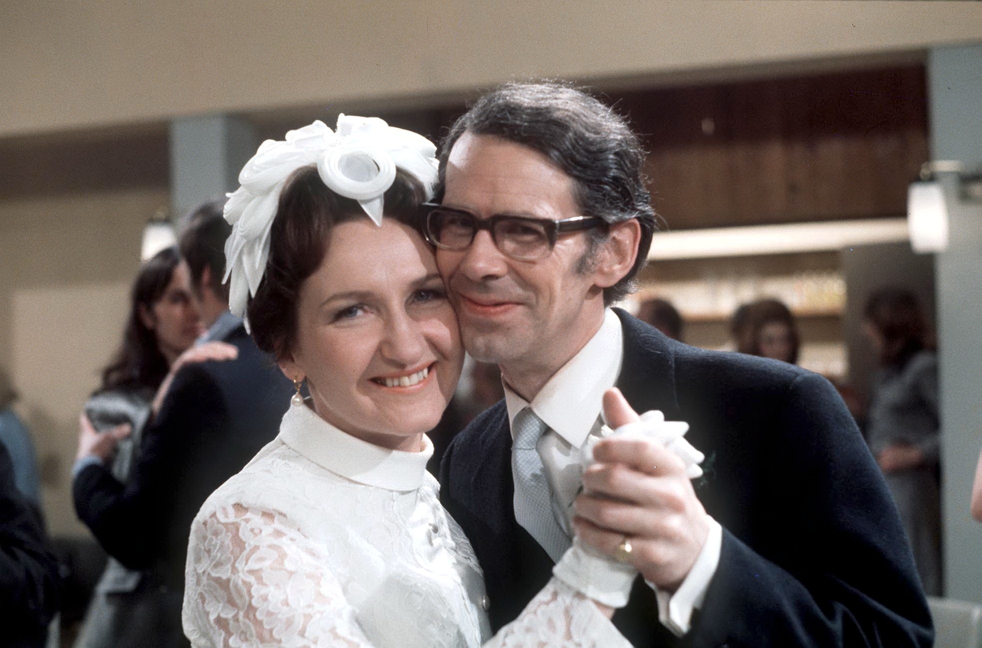 Bride and groom Emily and Ernest Bishop smile as they dance on their wedding day