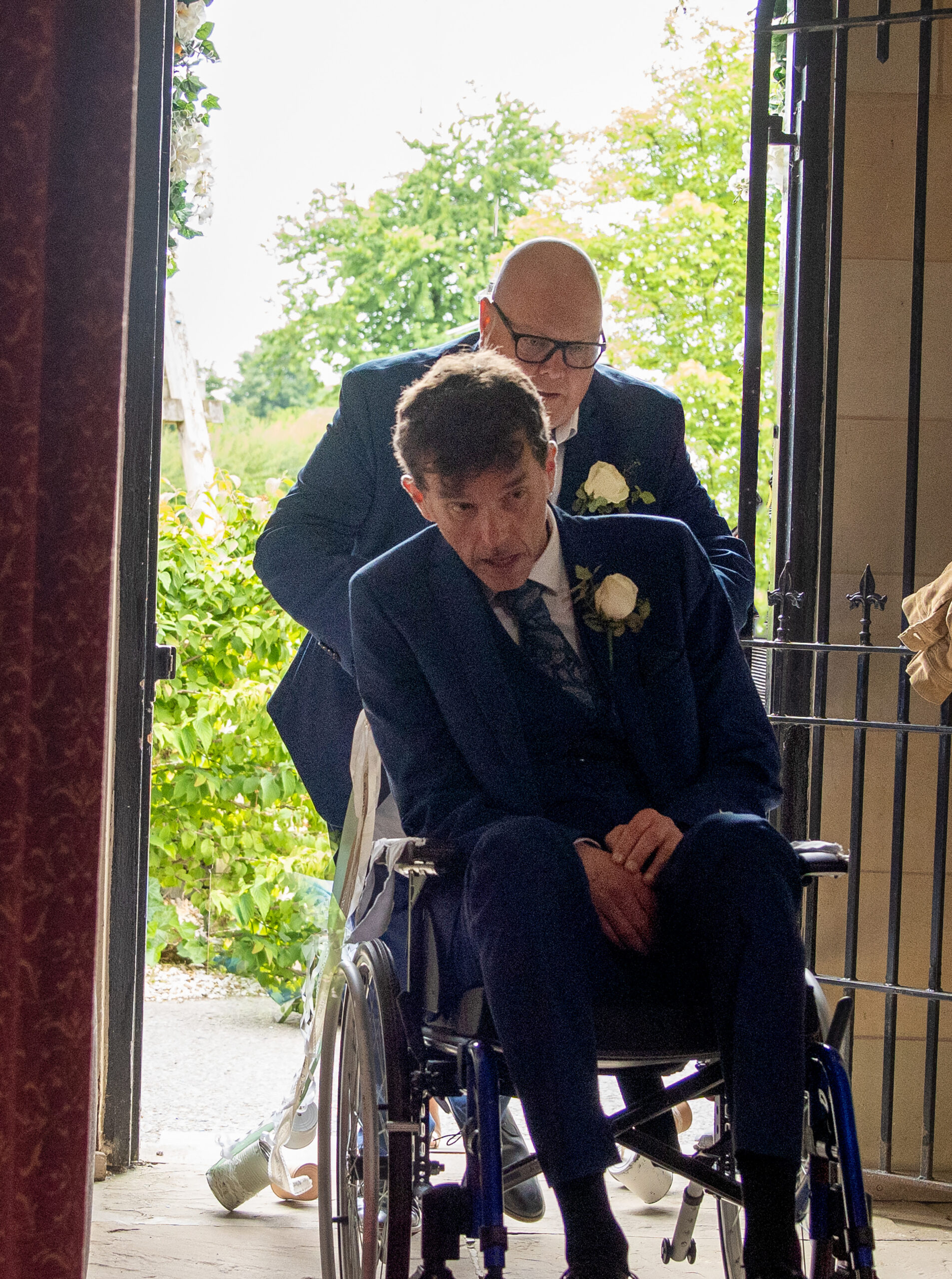 Marlon being pushed into church by Paddy in his wheelchair