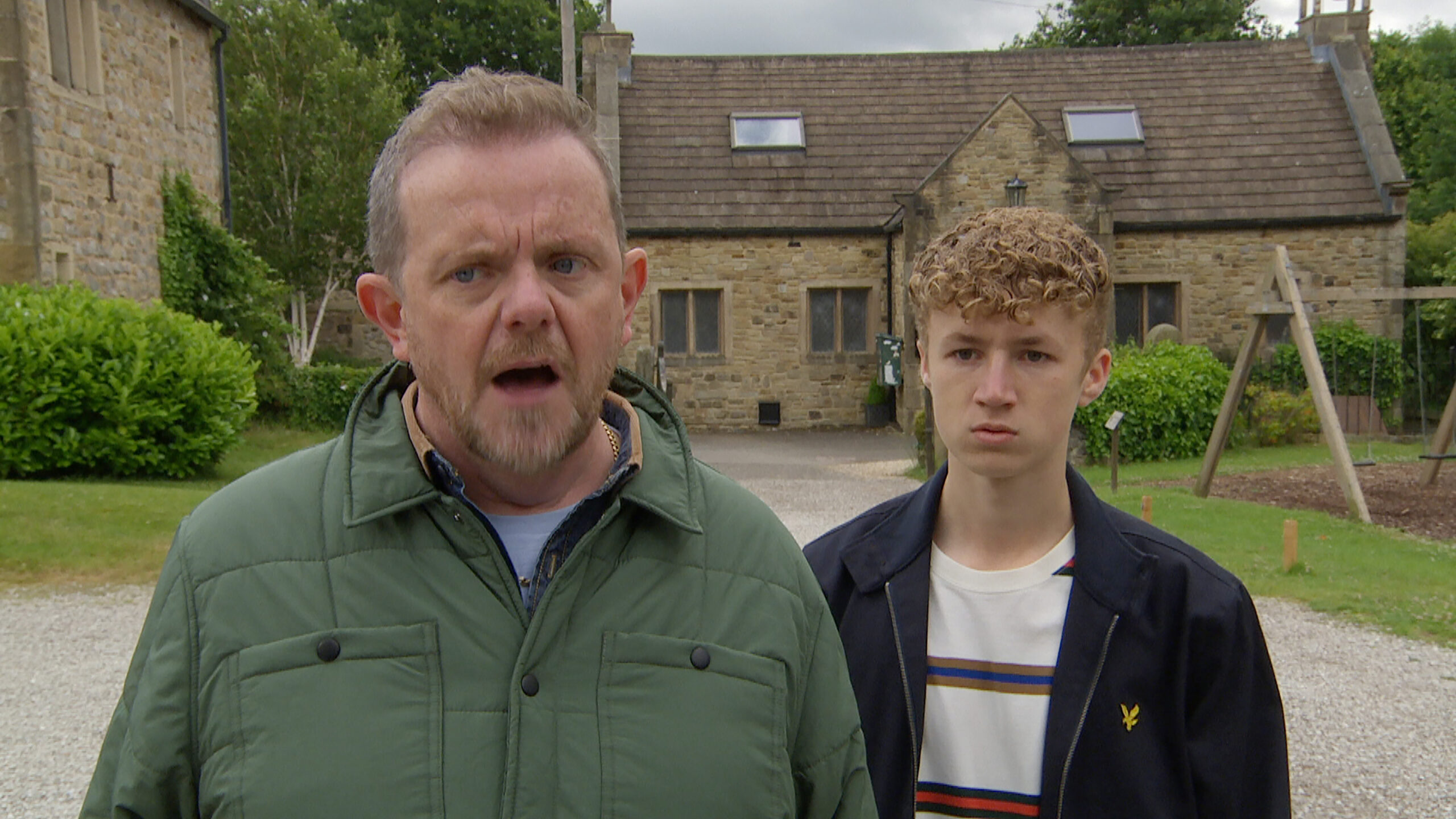 Emmerdale Dan looks angry with Noah behind him