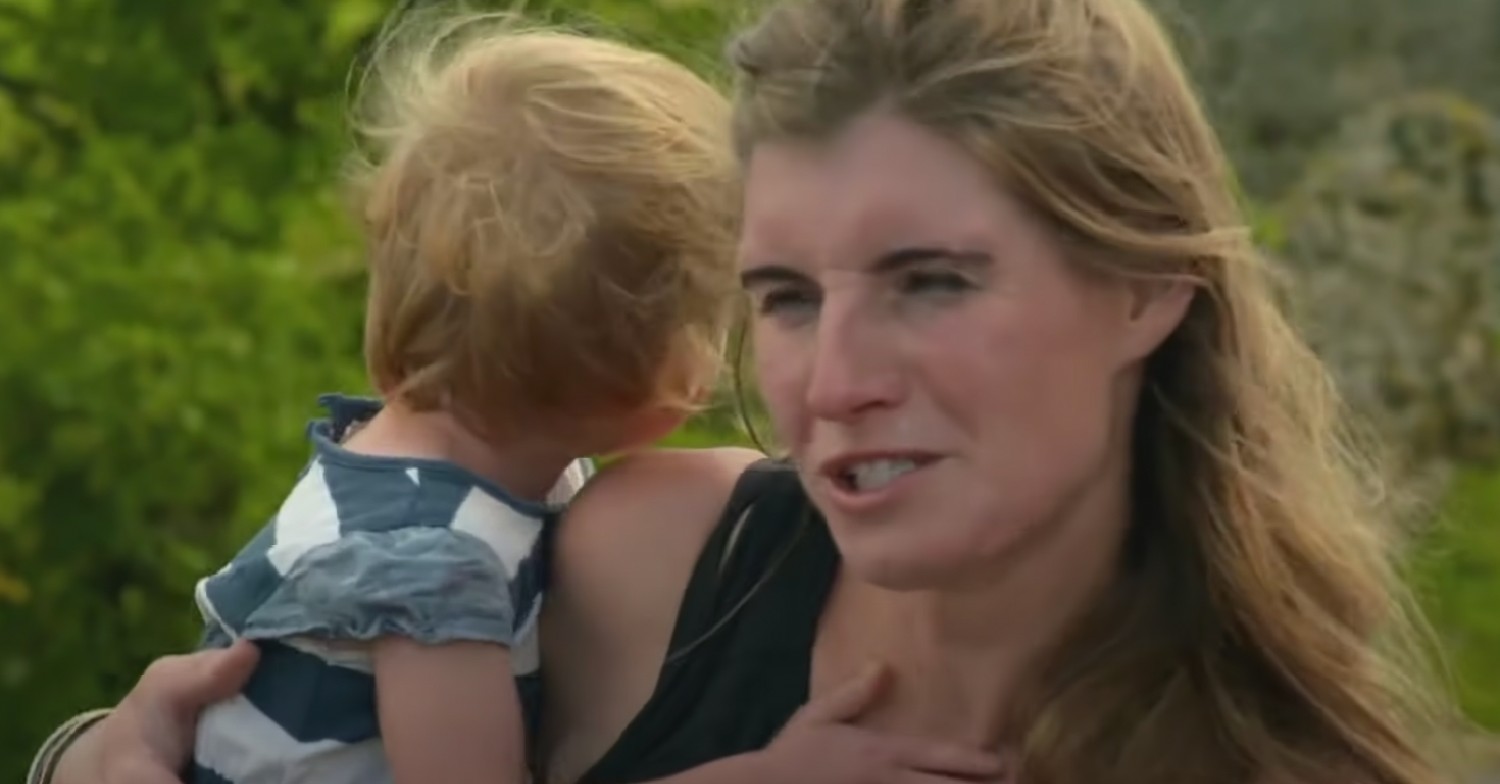 Amanda Owen outside carrying small child