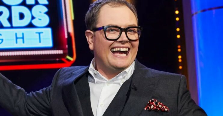 Alan Carr smiling on his ITV gameshow and wearing a suit