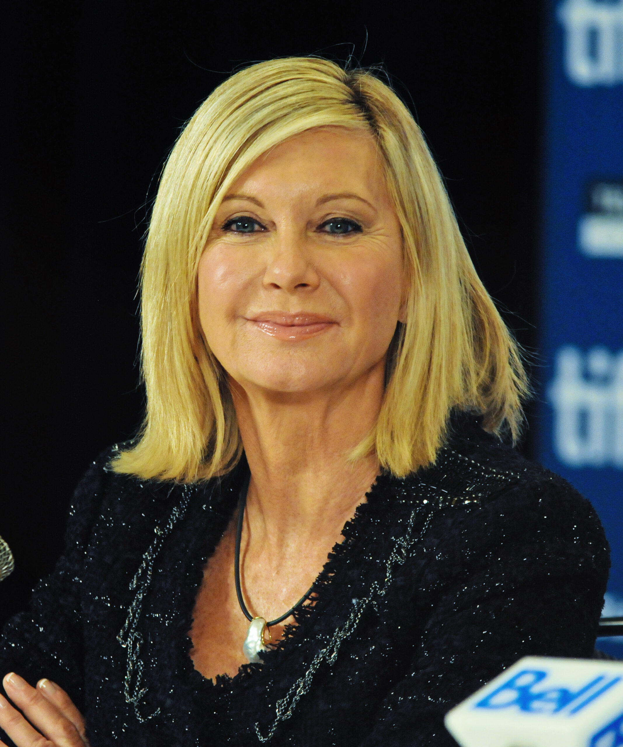 Grease star Olivia Newton-John wearing black and smiling