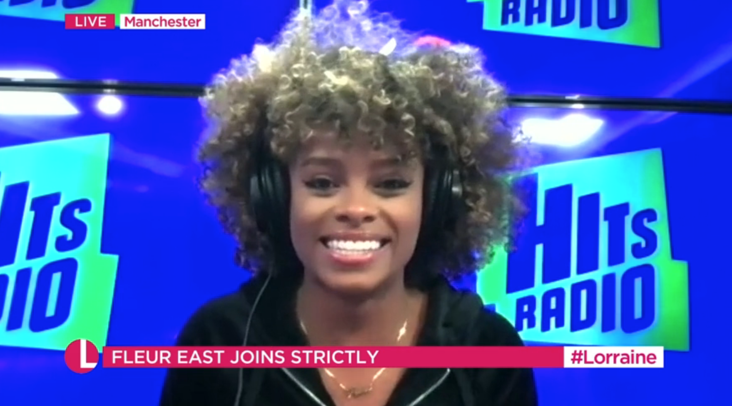 Flear East wearing headphones smiling