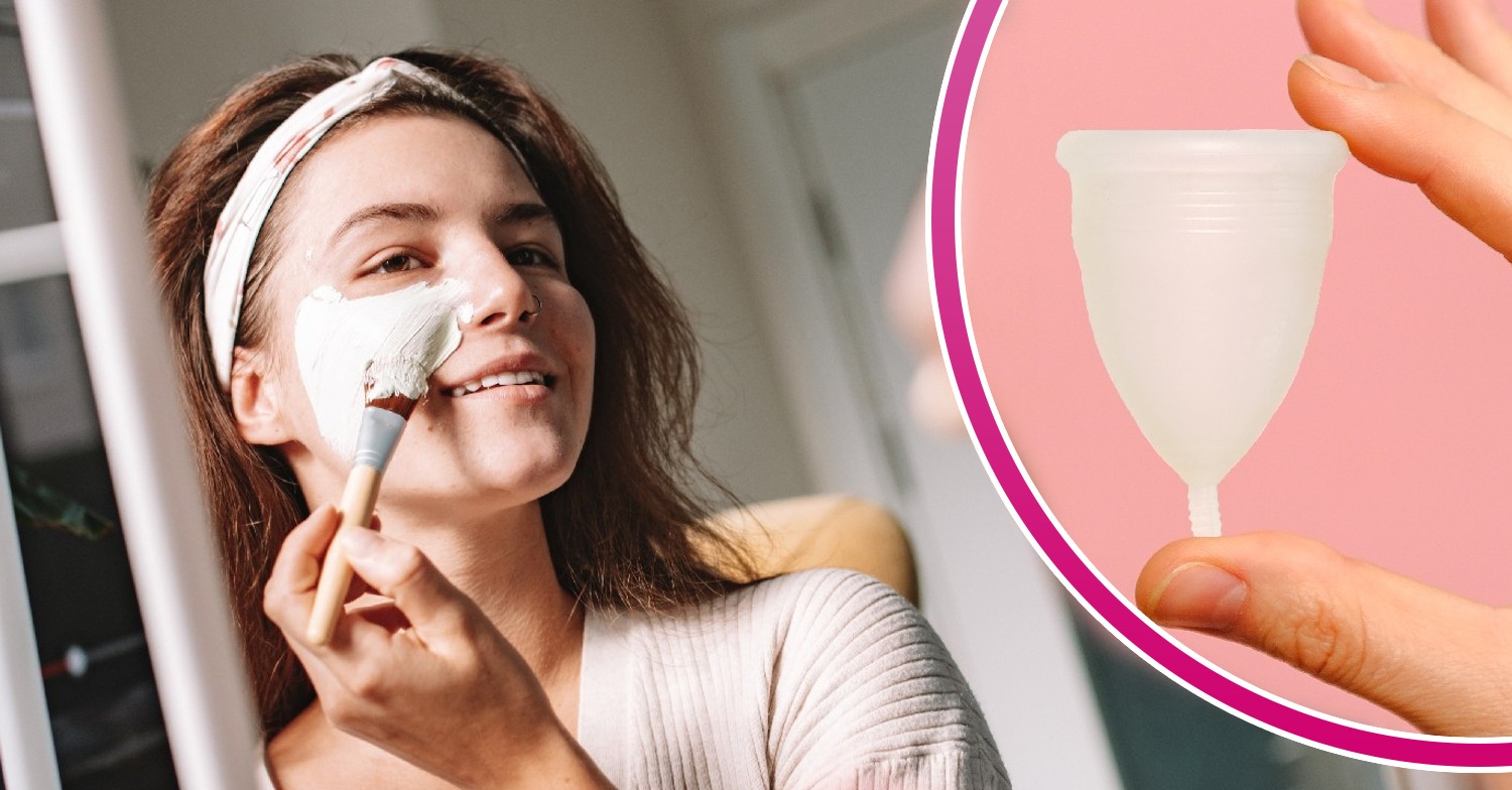 Woman putting on face mask in the mirror and a menstural cup