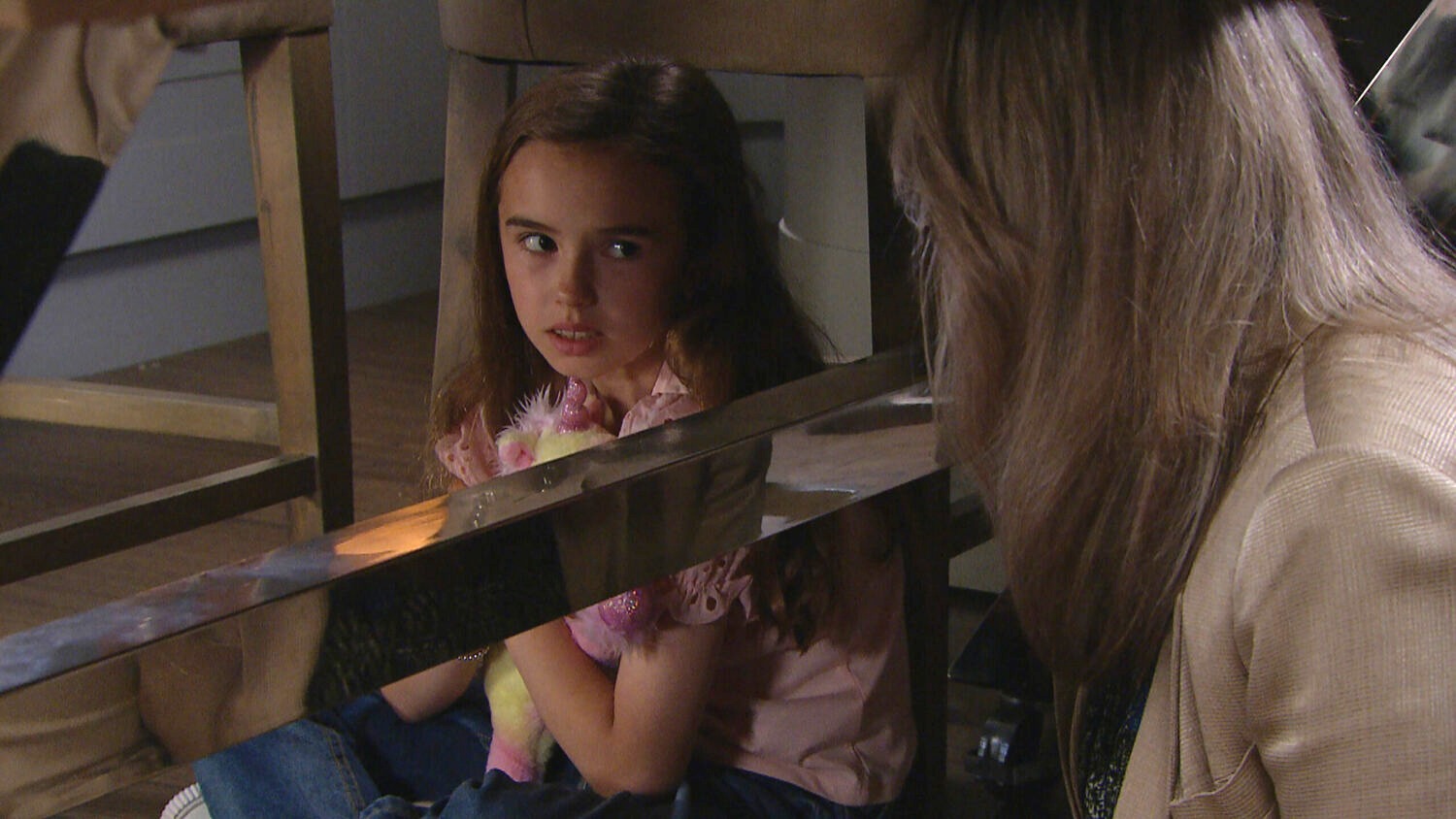 Millie Tate looking scared at Kim sat under a table 