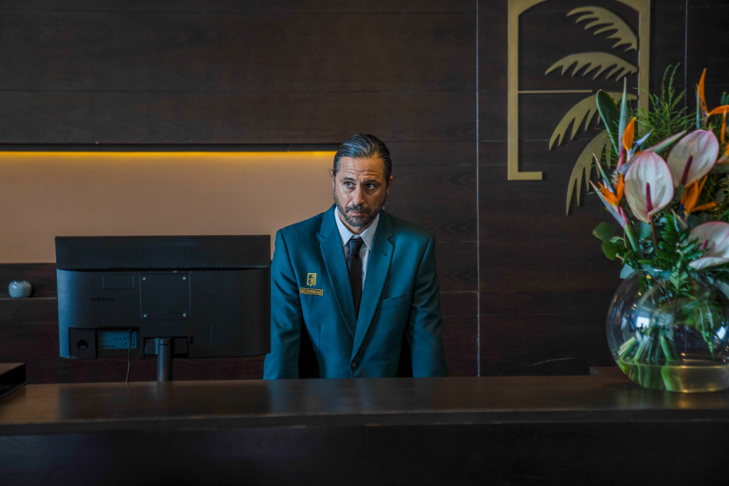 Mateo behind his desk at the hotel in Crossfire