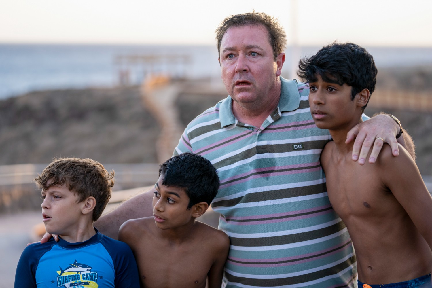 Daniel Ryan with his arms around three kids in Crossfire