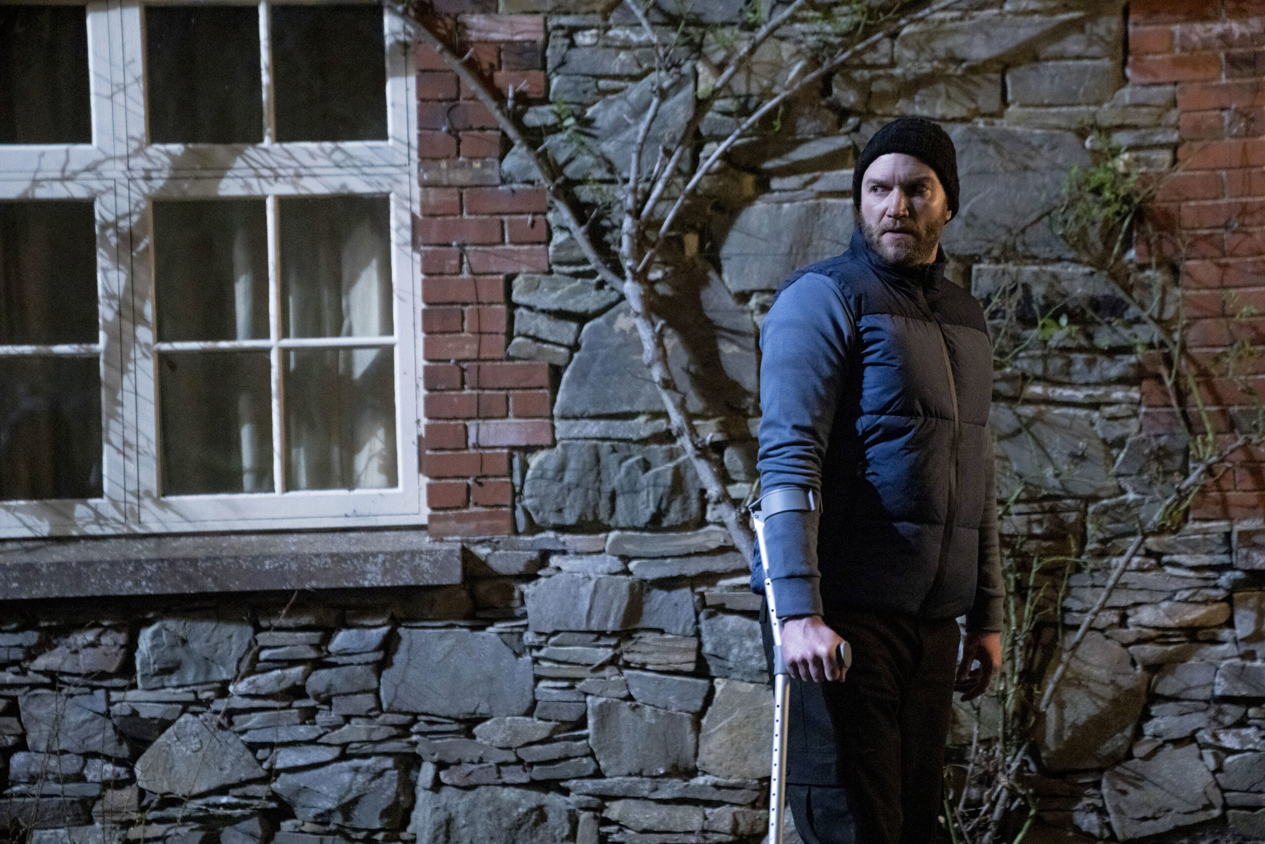 ,Robert Dardis (DIARMAID MURTAGH), he stands outside the safe out in crutches, looking to his left 