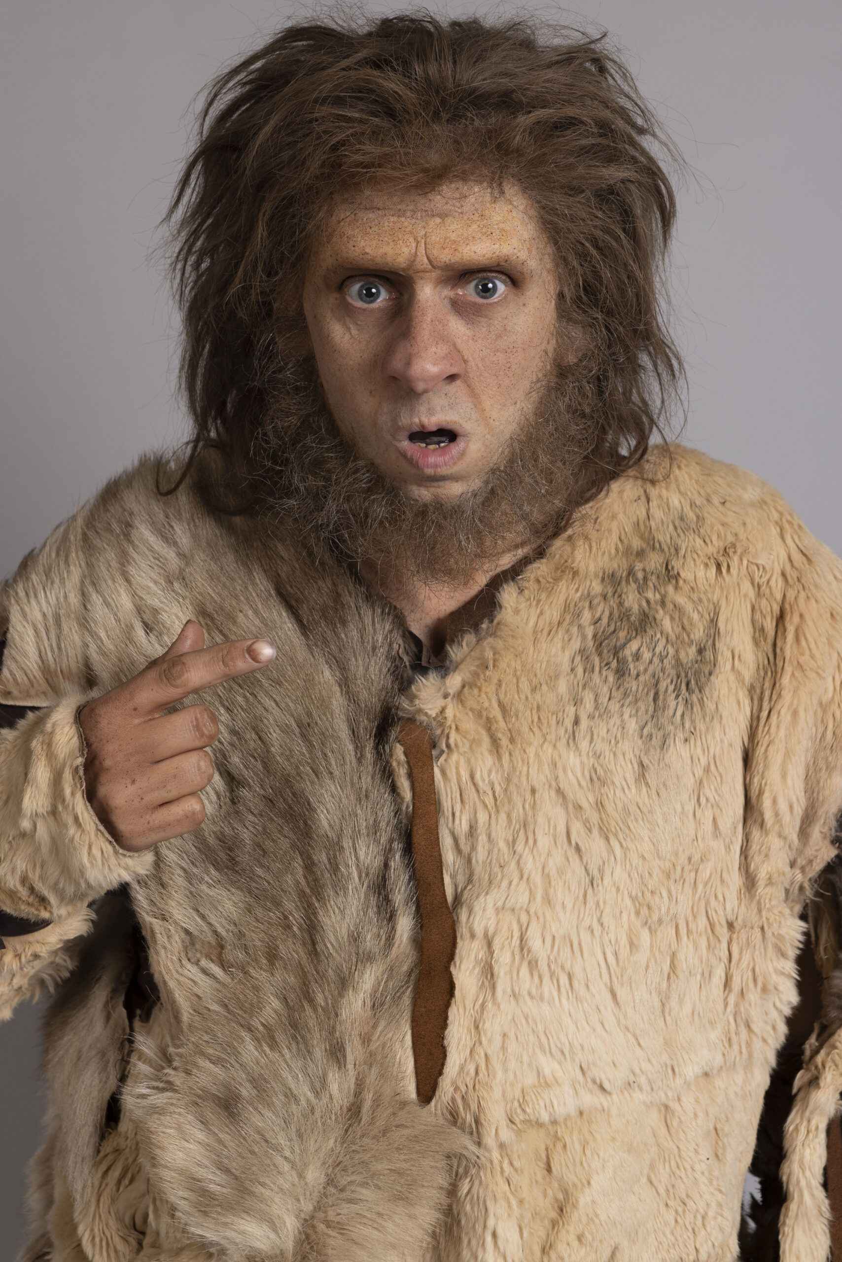 Larry Rickards as Robin, he gasps at the camera in a stereotypical cave woman costume