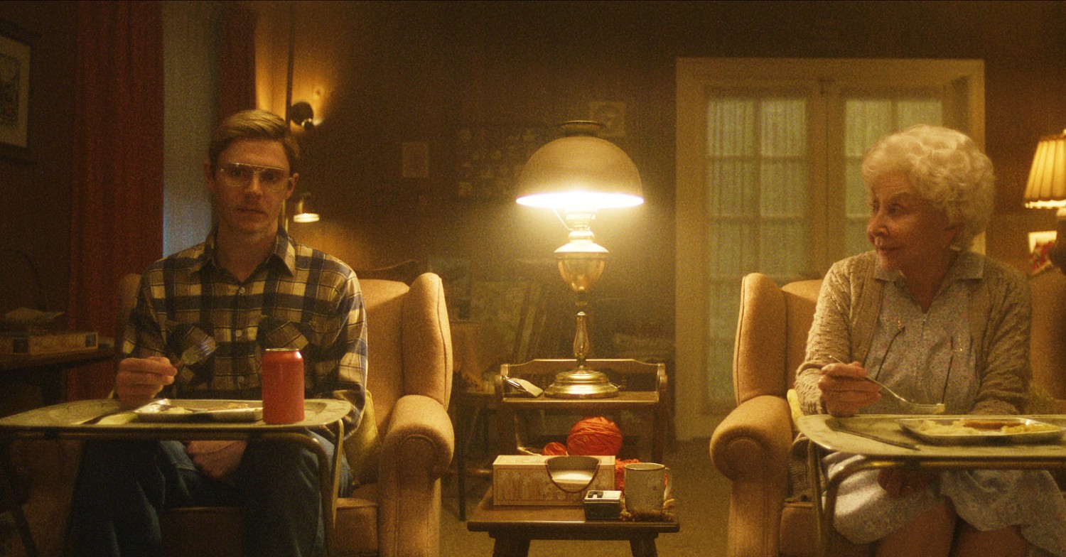 Evan Peters sitting with Michael Learned in Monster: The Jeffrey Dahmer Story