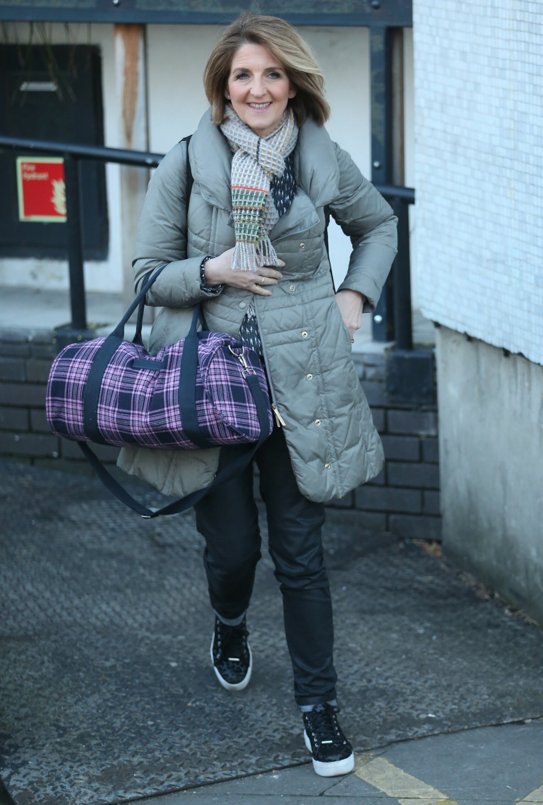 Kaye Adams smiles while carrying bag outside ITV Studios