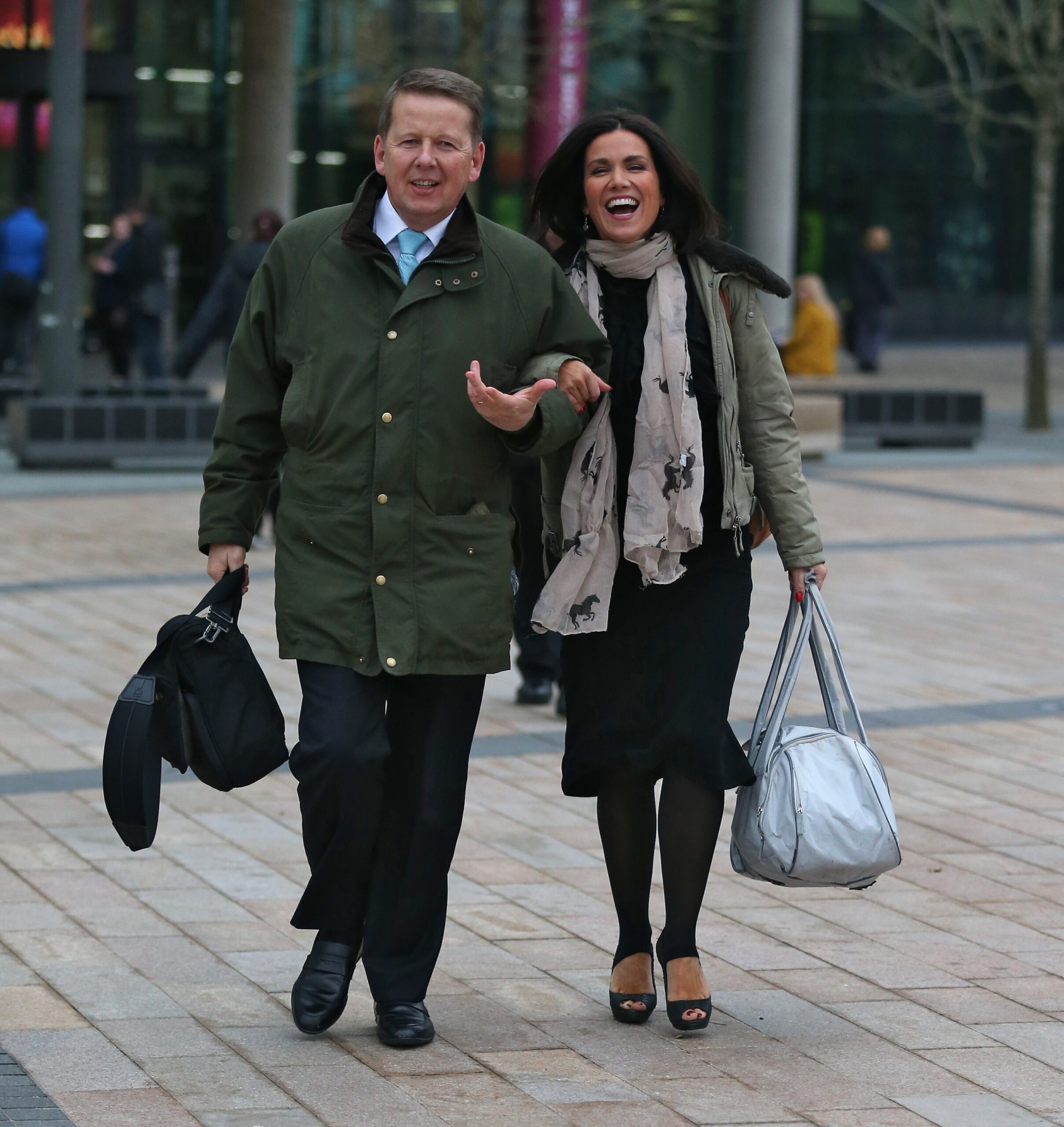 Bill Turnbull and Susanna Reid walk arm in arm laughing. 