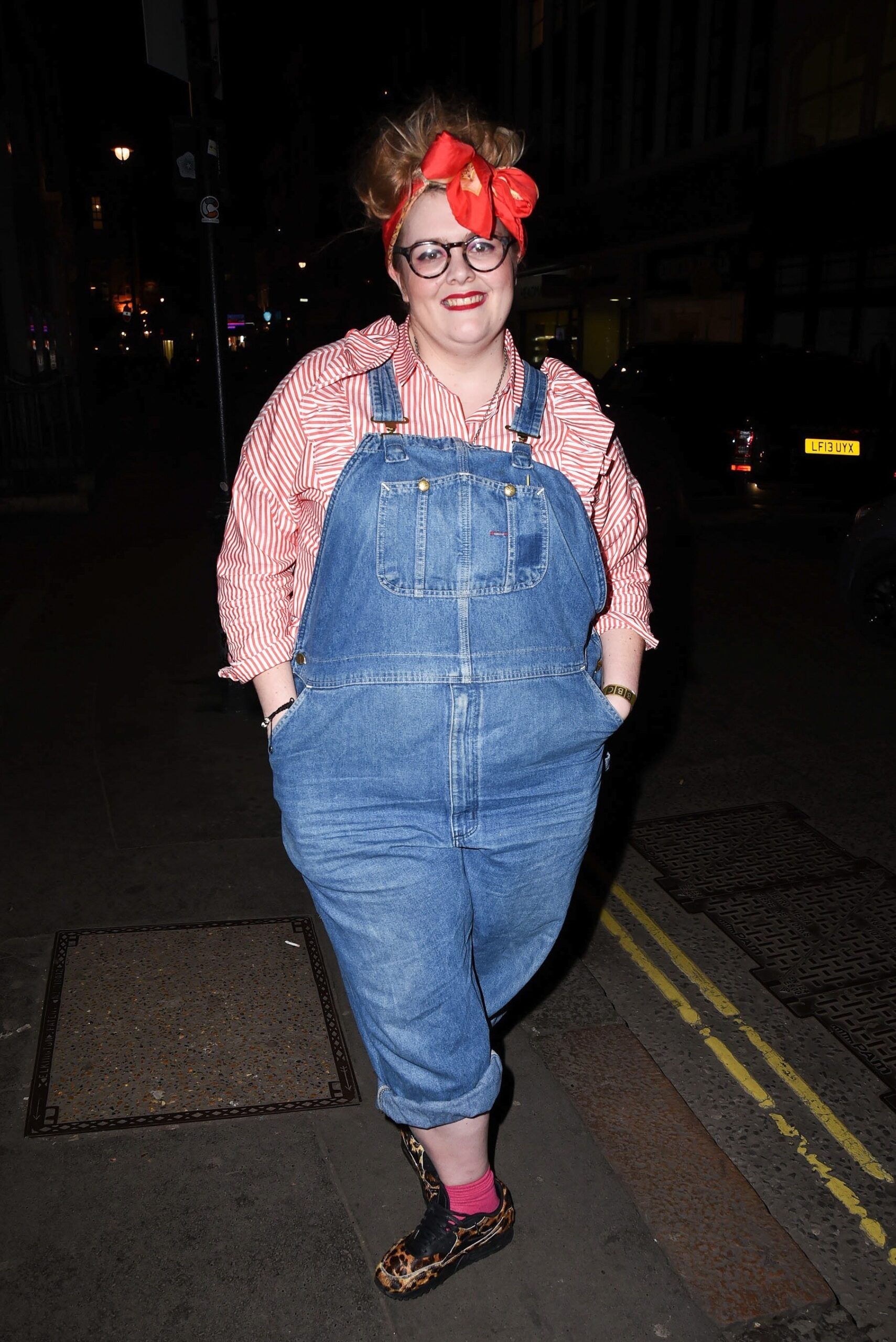 Jayde Adams in denim dungarees and red hair bow