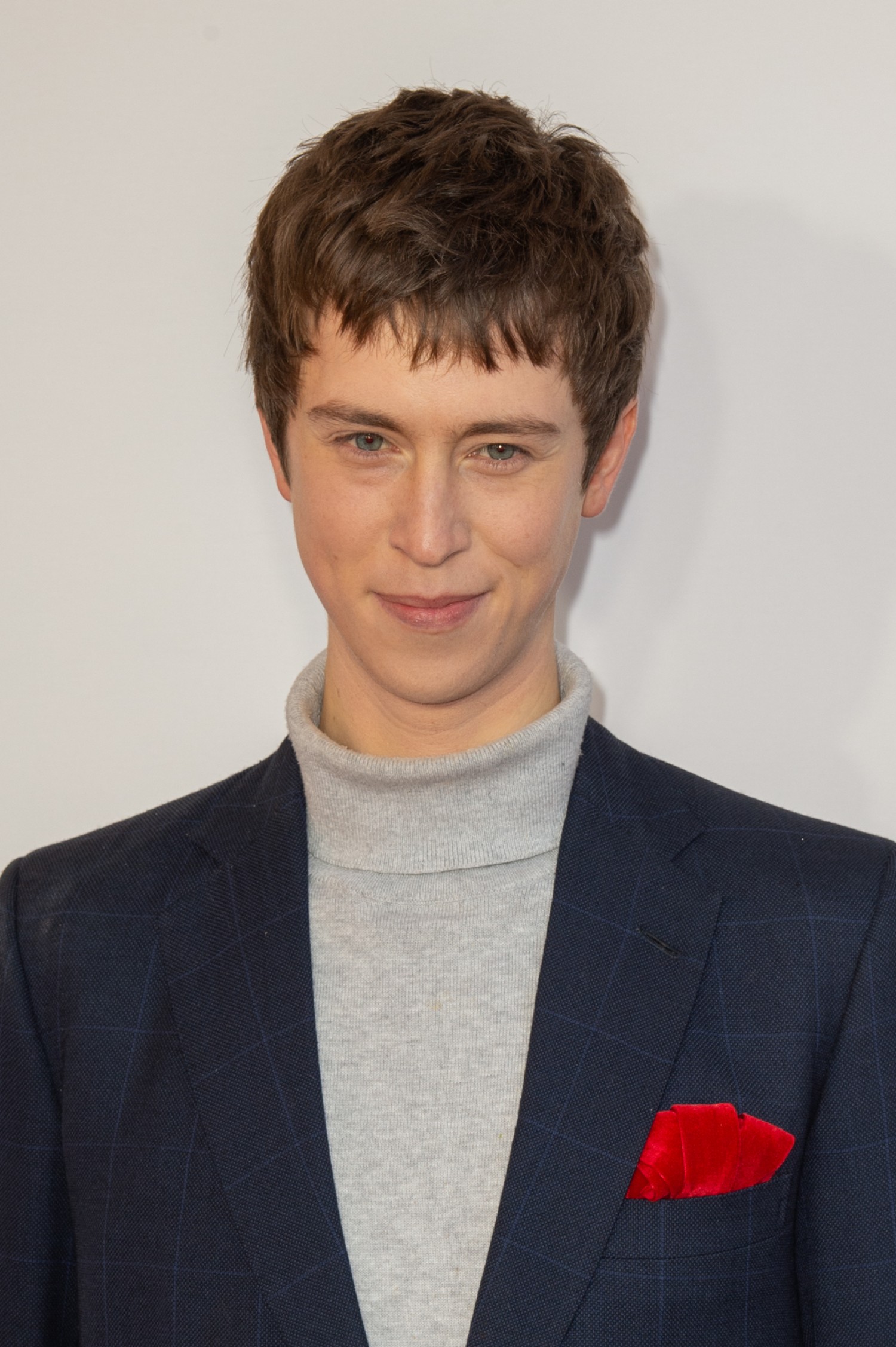 Angus Imrie smiling on the red carpet