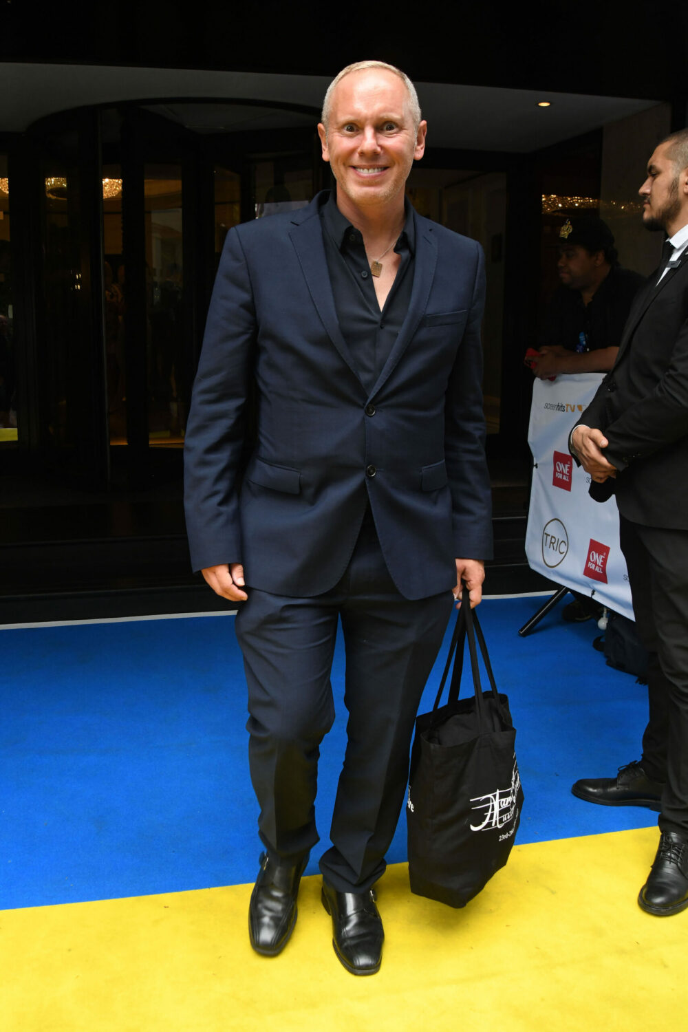 Robert Rinder smiles as he leaves the Tric Awards