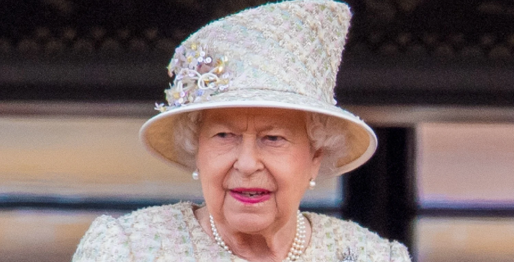 The Queen smiling in a beige hat