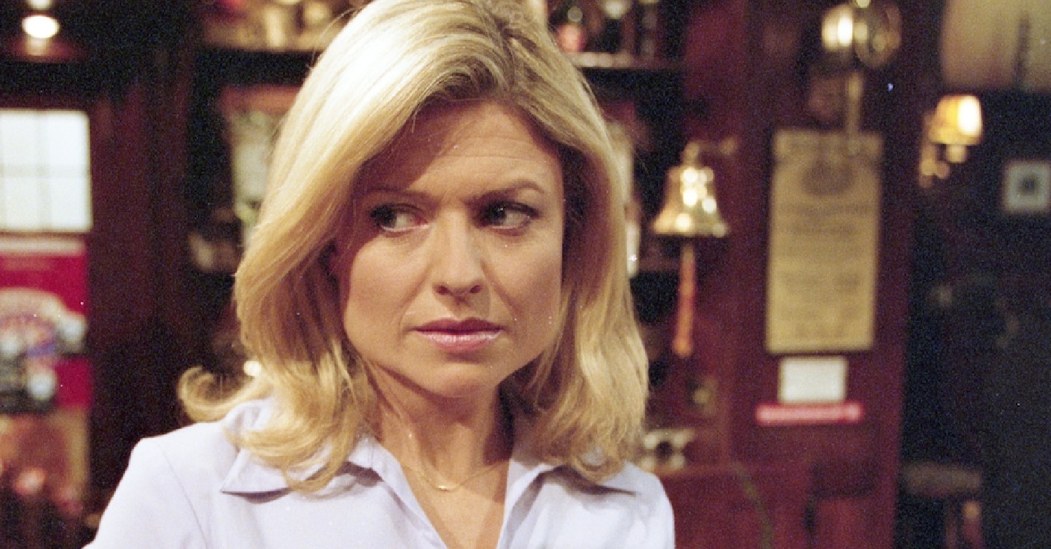 Blonde woman behind a bar looking concerned