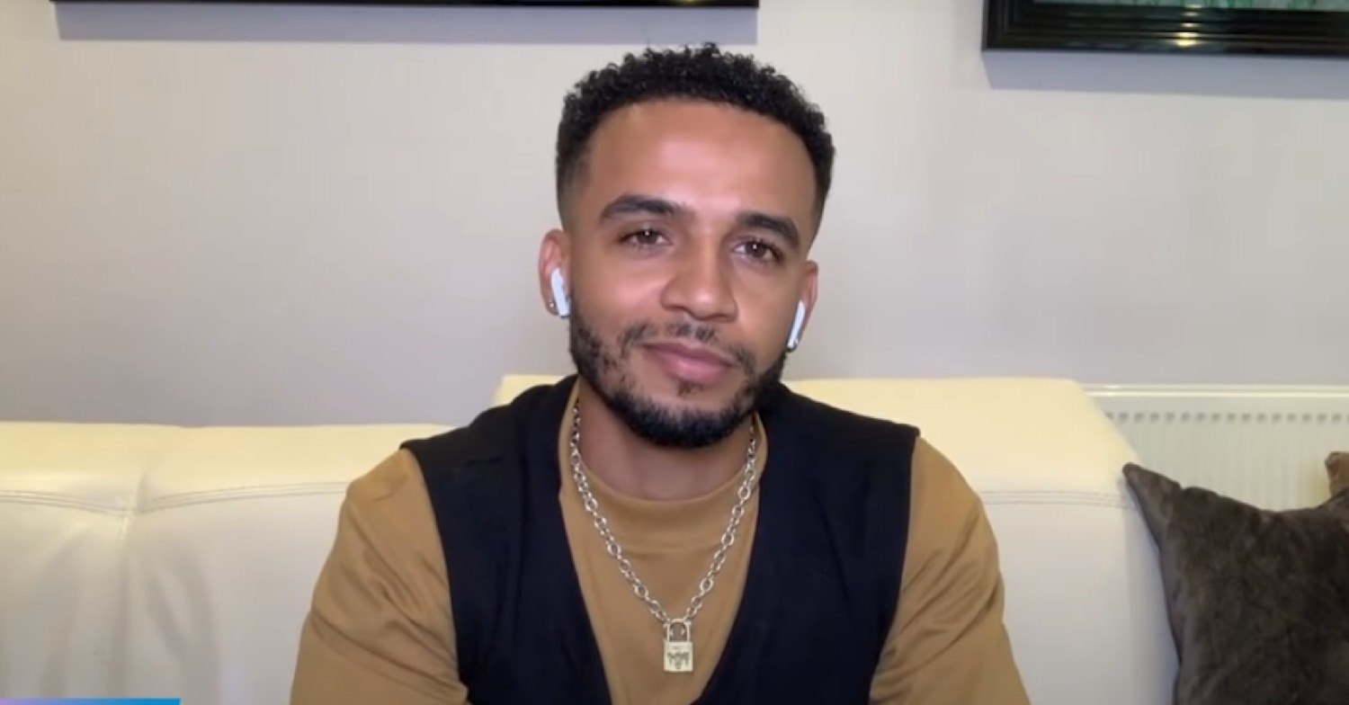 Aston Merrygold smiling while on video call 