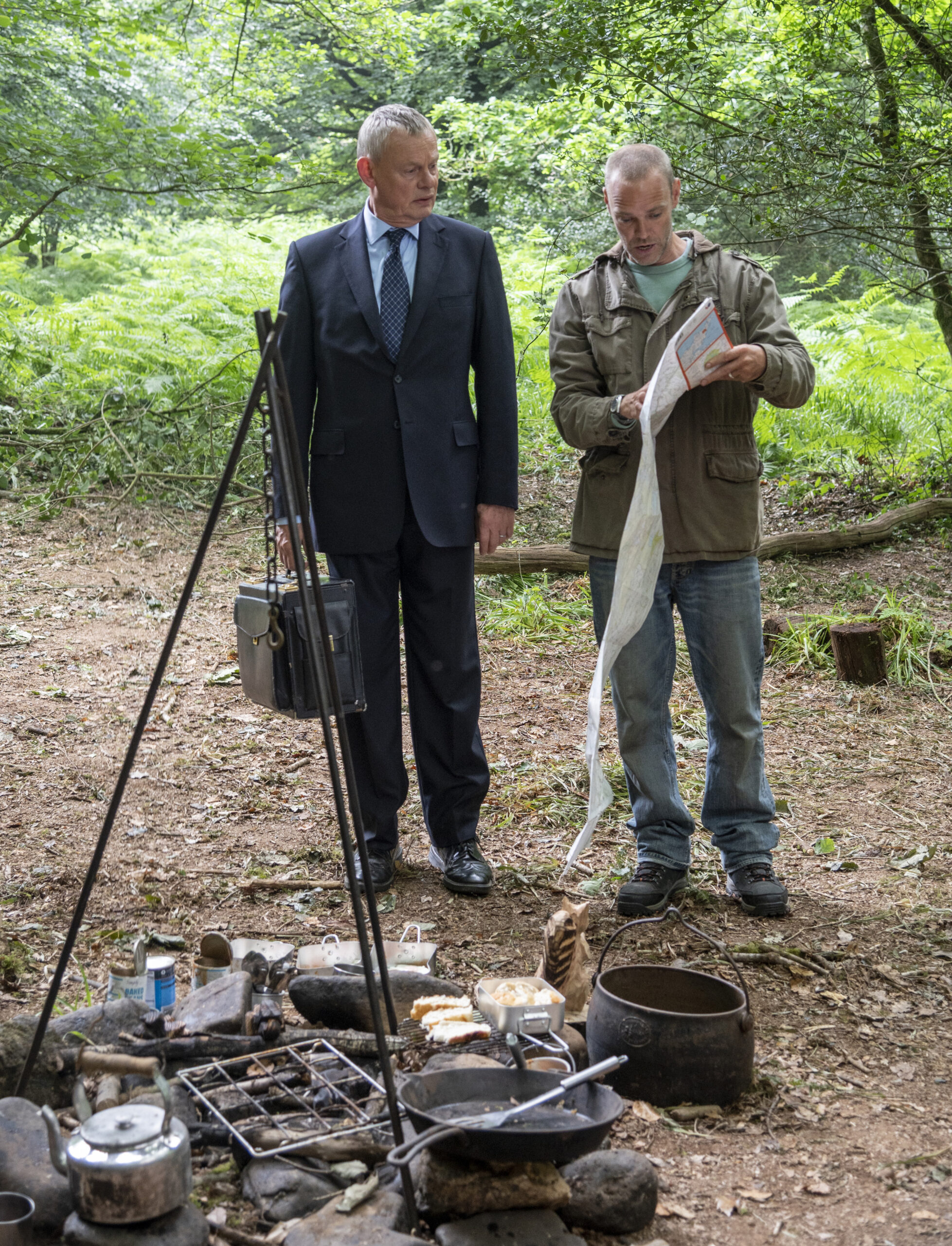 Doc Martin and Al Large look at a map in the woods