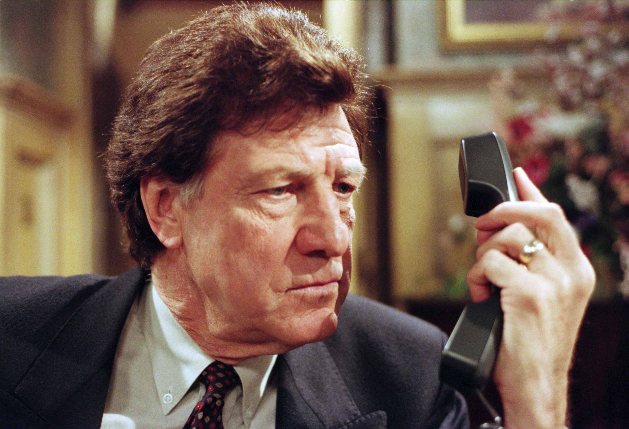 Frank Tate glares at his phone in Emmerdale